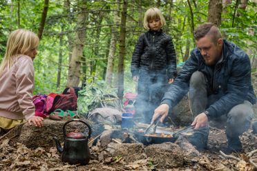 En pædagog i Lille-Gryn laver mad på bål til børnene i skoven ved Svaneke på Bornholm.