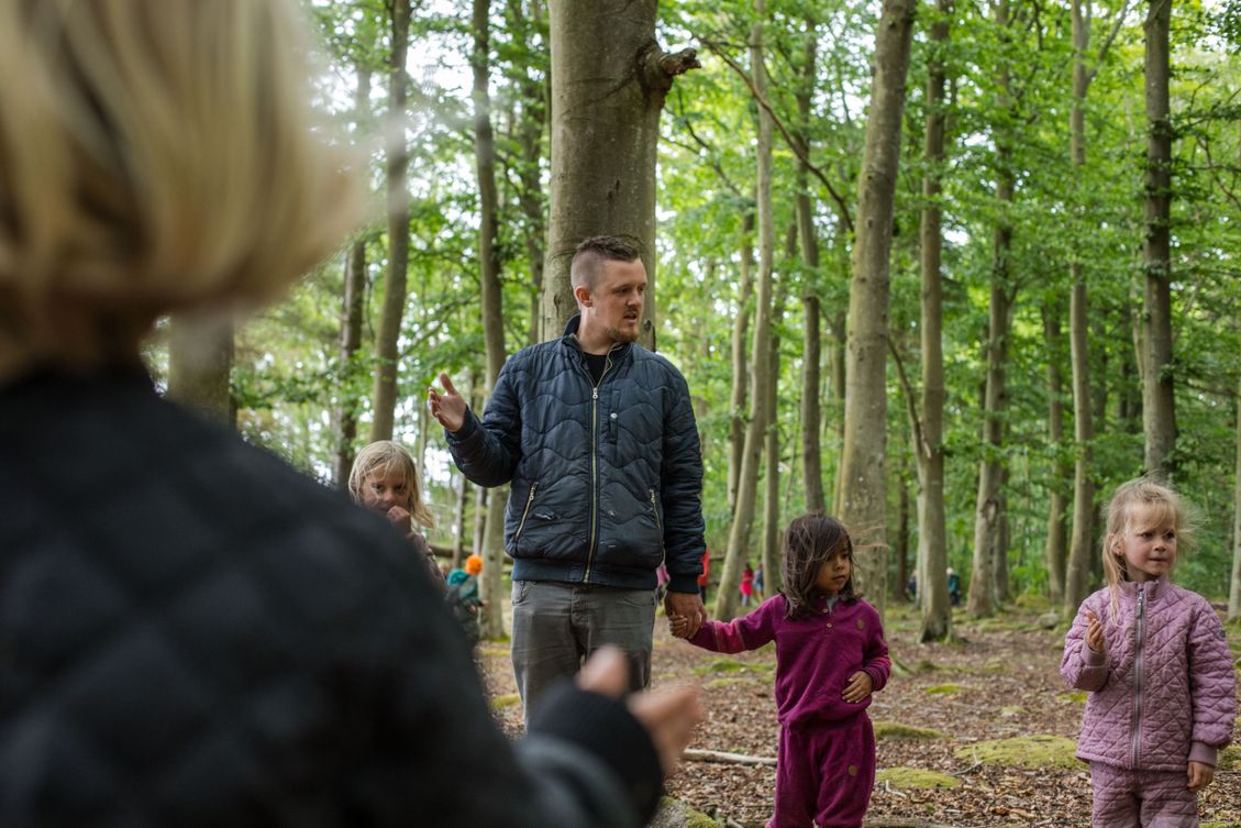 Skovgruppebørn i Lille-Gryn leger med de voksne i skoven ved Svaneke på Bornholm.