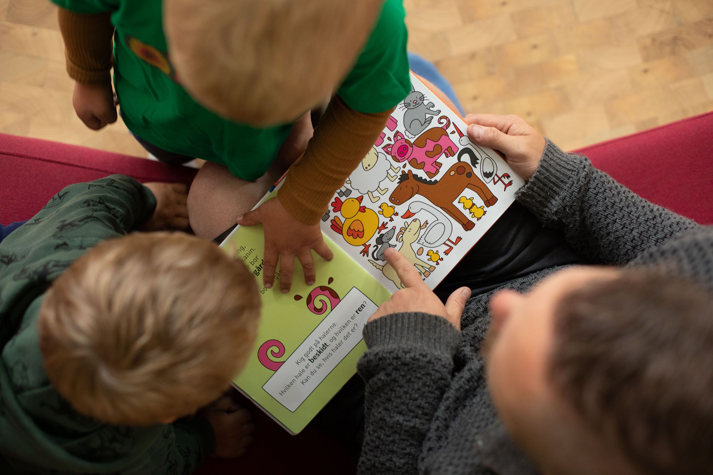 Voksne læser bøger for børnene indenfor i Naturbørnehaven Lille-Gryn.