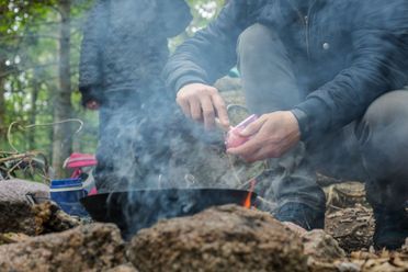 En pædagog i Lille-Gryn laver mad på bål til børnene i skoven ved Svaneke på Bornholm.