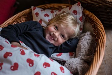 Barn sover middagslur i en hundekurv i Lille-Gryn.